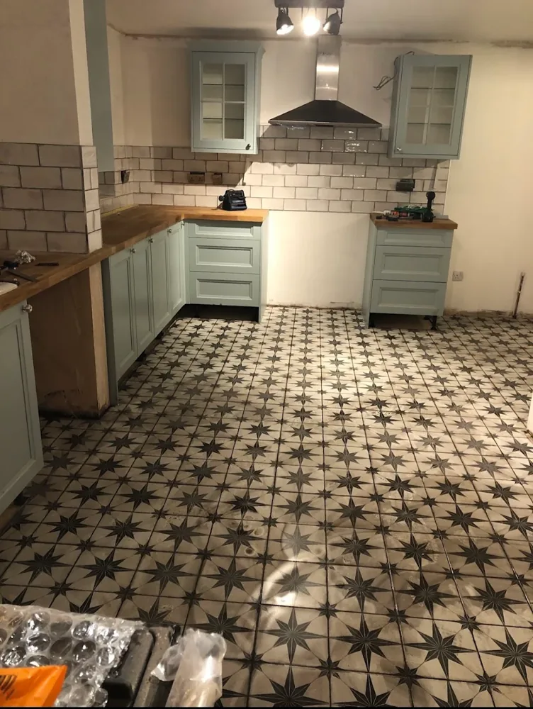 Kitchen renovation by Sharra Construction in Oxford: pale blue shaker units, oak worktops and a patterned tiled floor, photographed during fitting
